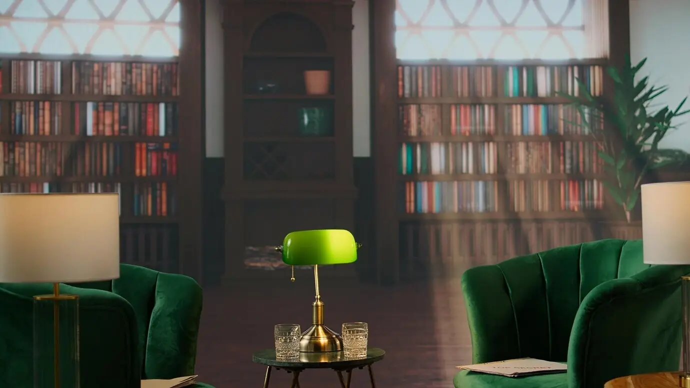 Eine gemütliche Bibliothek im Vintage-Stil mit grünen Stühlen und Whiskeygläsern schafft ein stilvolles Ambiente.